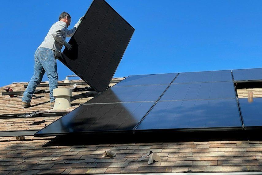 Mão segurando uma placa solar durante a instalação